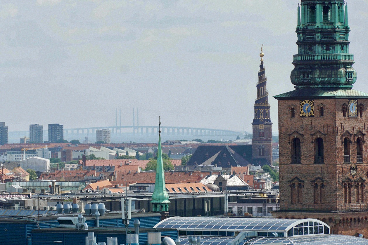 Blick über Kopenhagens Dächer zur Öresundbrücke am Horizont